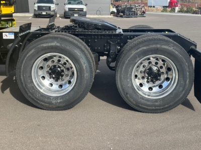 Twin rear axles of a Mack PR64T76H truck showing dual wheels and chrome rims.