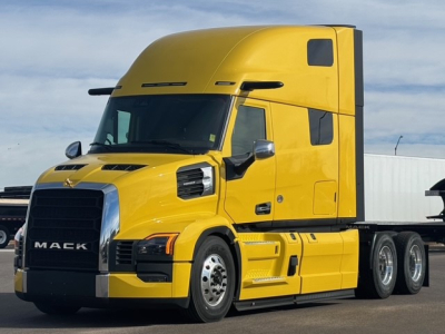 Mack PR64T76H conventional sleeper truck in yellow side view showing cab and front grille with Mack logo and chrome accents.