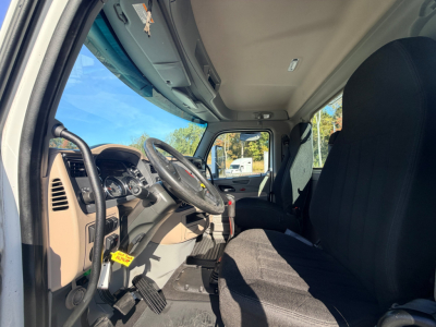 Truck cabin interior of a 2020 Peterbilt 567 showing the steering wheel, dashboard, pedals, and driver seat.