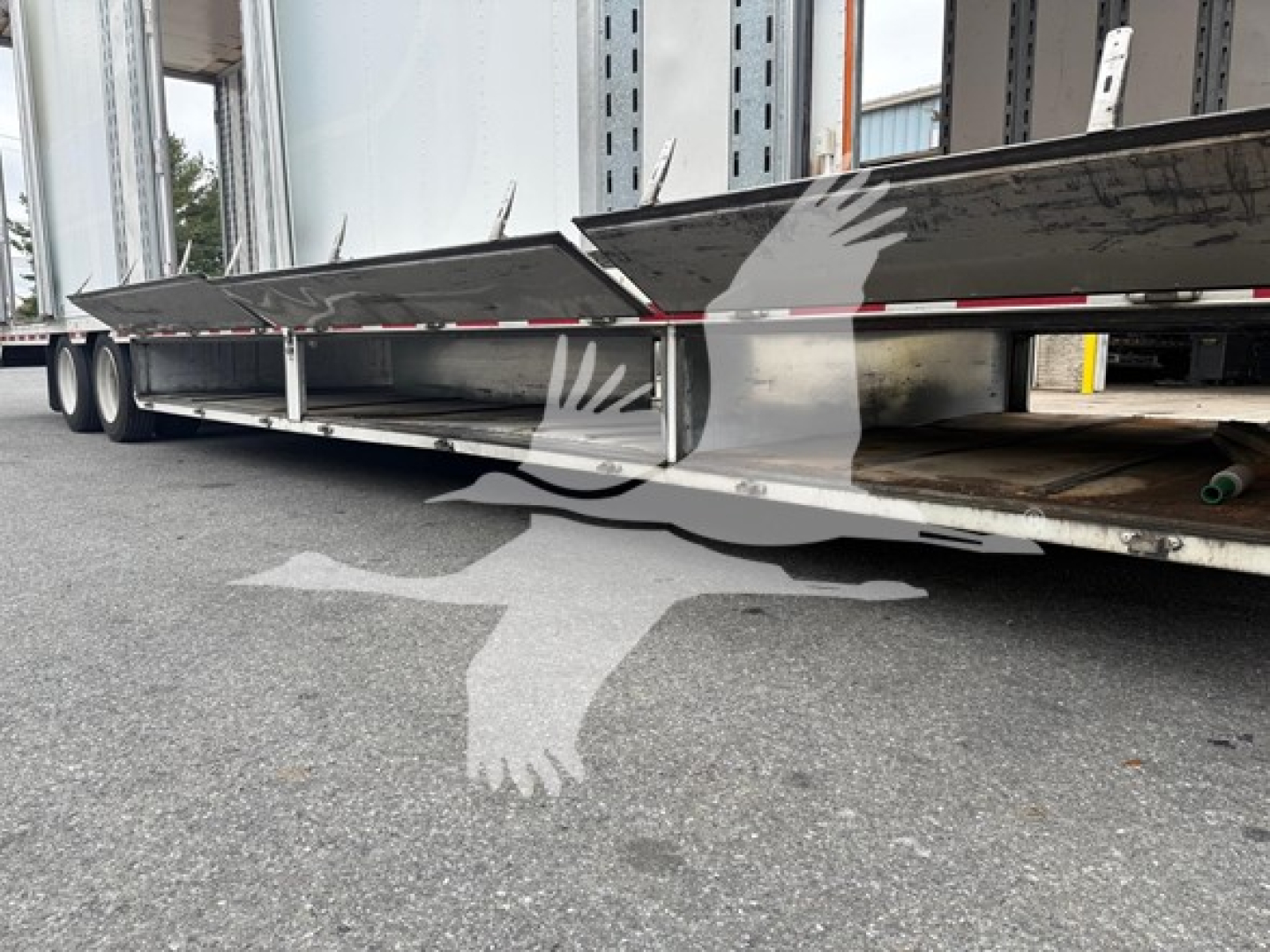 Trailer underside of a moving van with side skirts, metal frame, and wheels visible under the trailer.