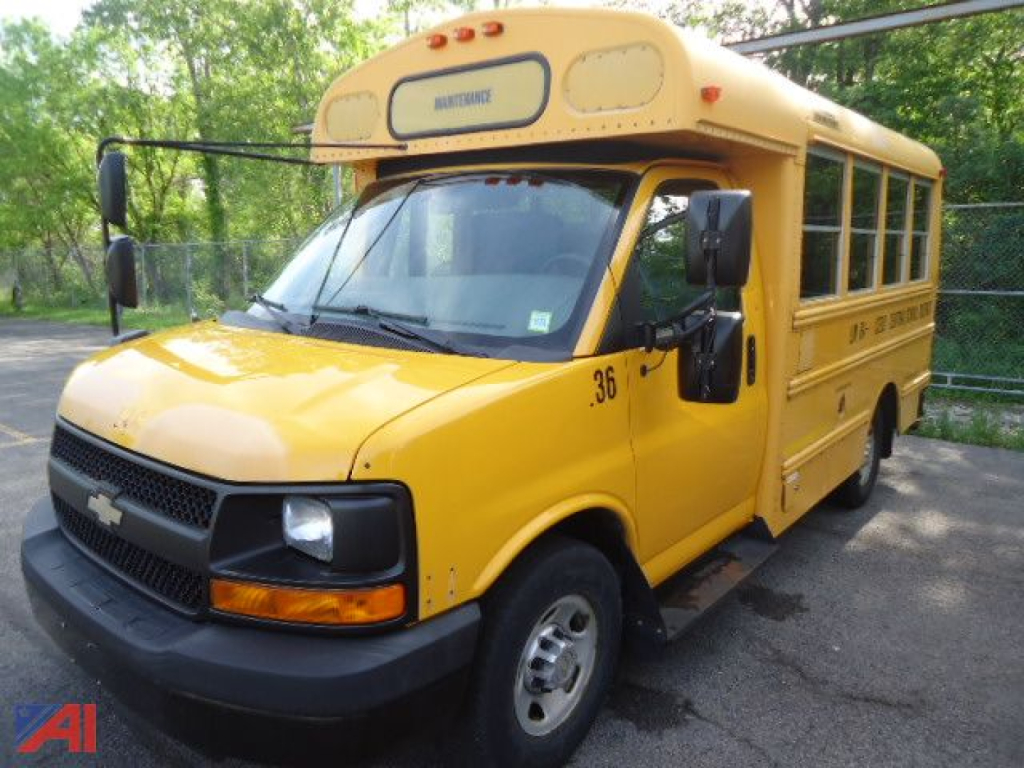 Yellow 2014 Chevrolet Express/Thomas school bus side view with stop sign missing, showing bus number 36 and label on hood, daytime outdoor lot