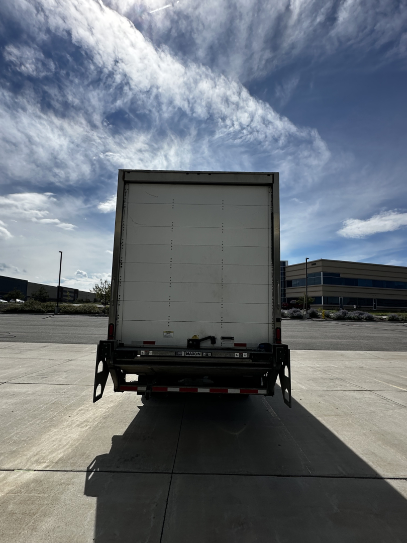  Freightliner M2-106 rear view showing cargo box with warranty/serial stickers and taillight area.