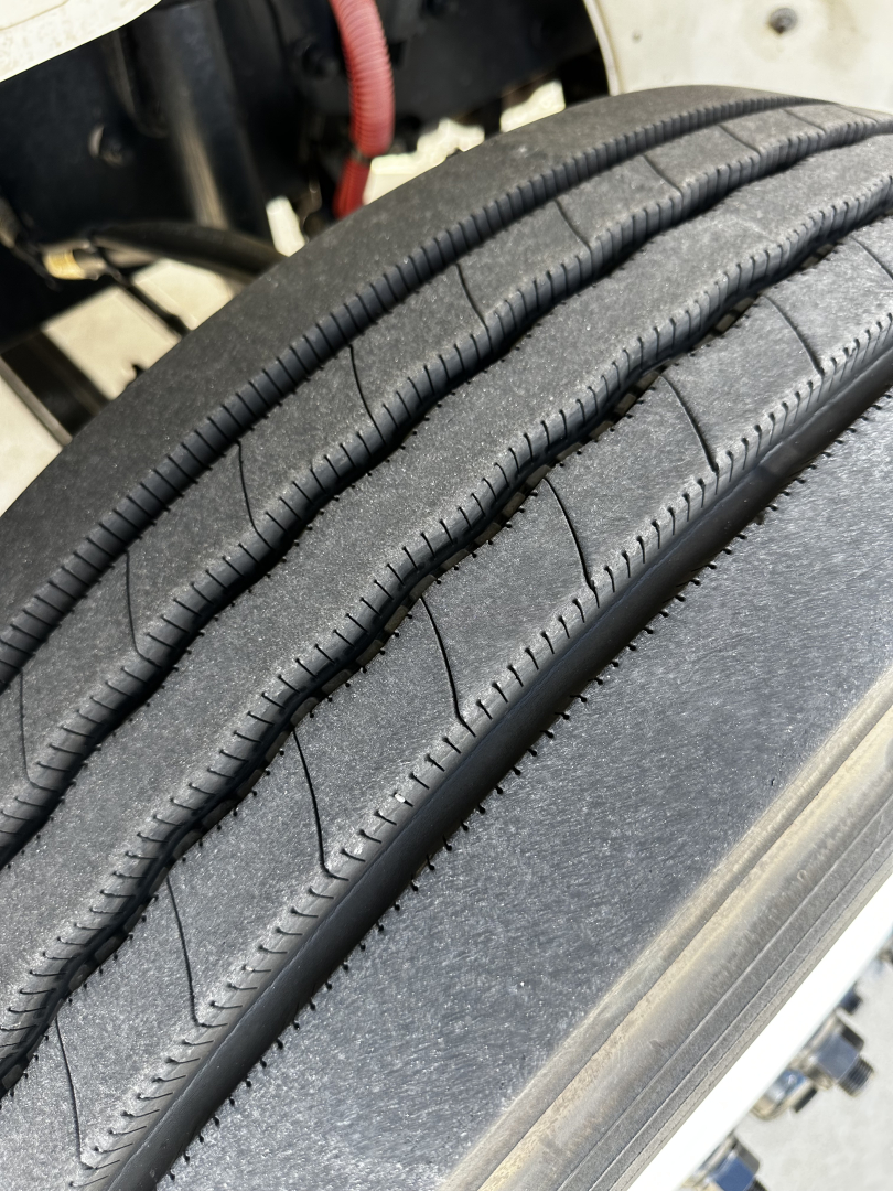 Tire tread and sidewall detail on Freightliner M2-106 chassis highlighting tire surface and wheel well.