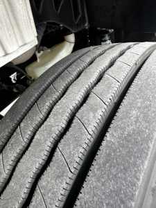 Wheel/tires of a Freightliner M2-106 showing tread detail and suspension components.