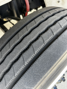 Tire tread and sidewall detail on Freightliner M2-106 chassis highlighting tire surface and wheel well.