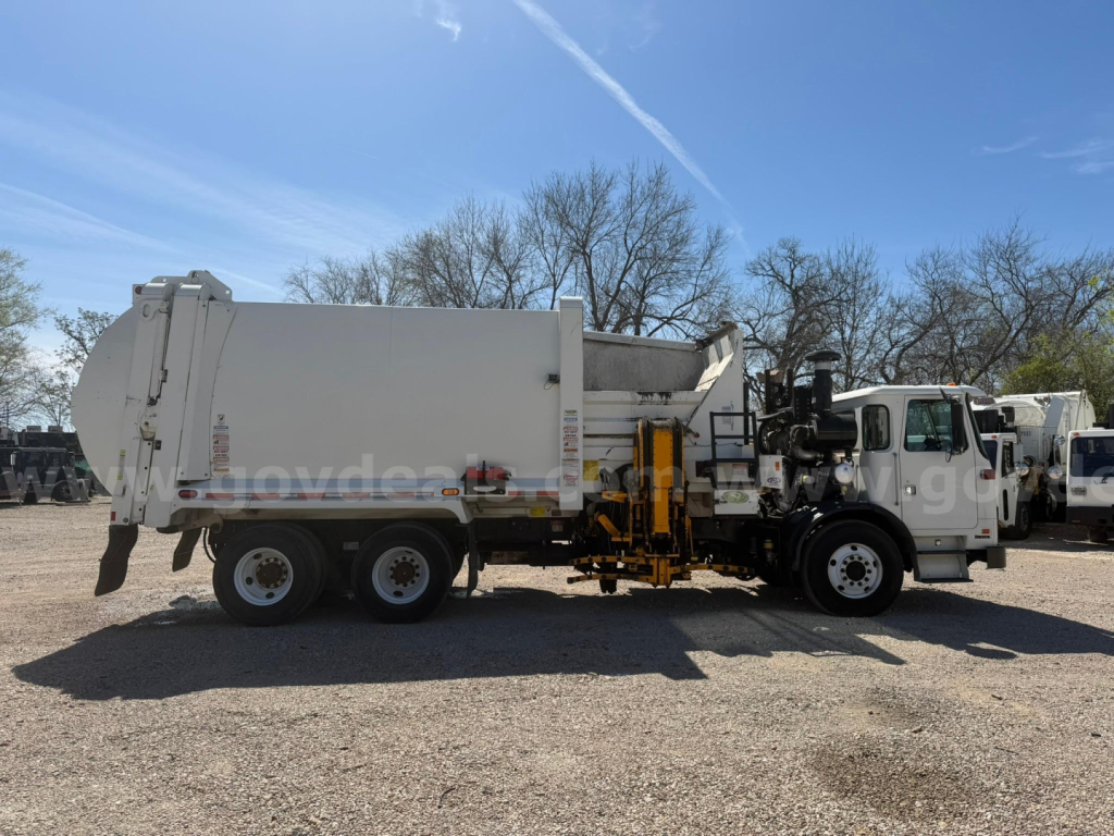 Autocar Xpeditor front-half view with a large dump body on a commercial truck, side view showing hydraulic arm and dual rear axle.