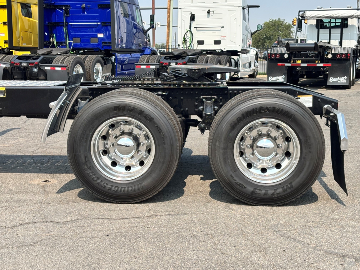 Mack PI64T chassis with dual rear axles and wheels visible; no cab, showing tire details and frame.