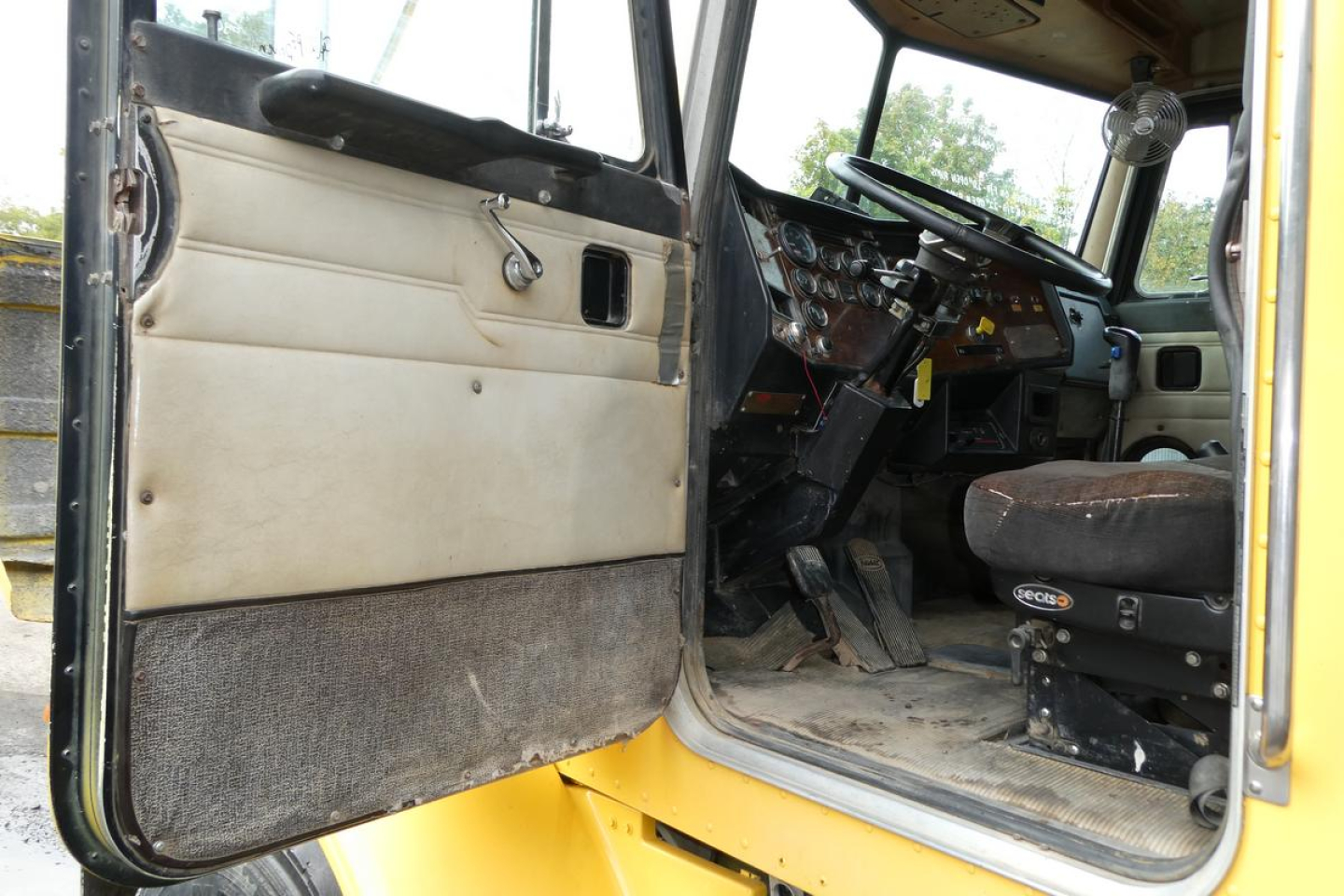 Peterbilt 357 truck cab interior view showing dashboard and driver seat with open door