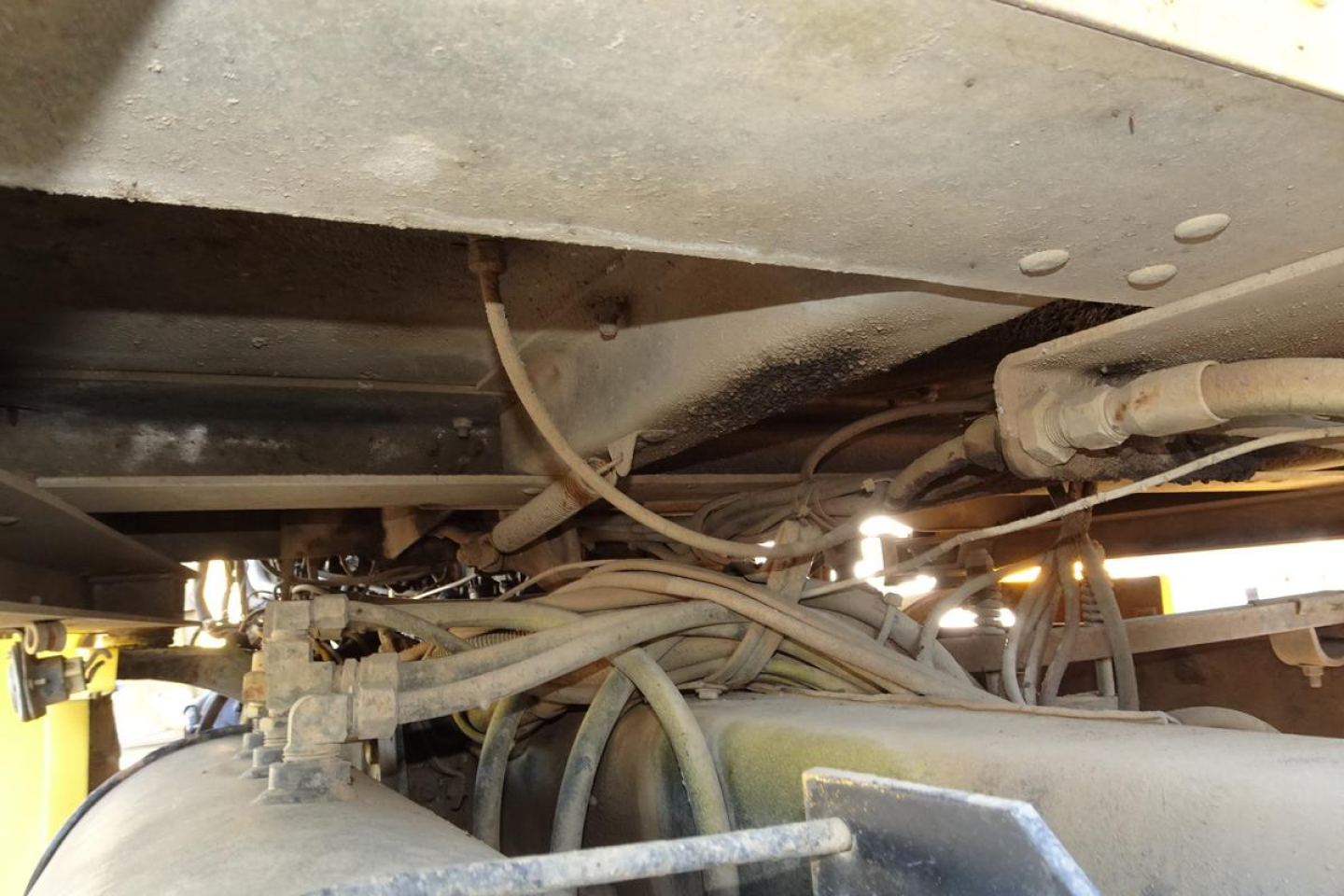 Peterbilt dump truck undercarriage showing fuel lines and frame with hoses