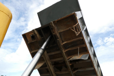 Dump truck bed and hydraulic lift from a Peterbilt 357 dump truck viewed from below with a clear sky.