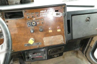 Peterbilt 357 cab interior dashboard with wood panel, switches, and gauges; ignition area and instrument cluster visible.