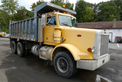 Peterbilt 357 dump truck in-service showing yellow cab and gray dump body, front grille, headlights, and side mirrors.