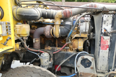 Peterbilt 357 engine bay showing exhaust, hoses, and radiator area with yellow body parts.