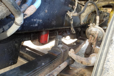 Peterbilt 357 dump truck undercarriage showing chassis frame, hydraulic lines, and suspension components with visible wear and grime.