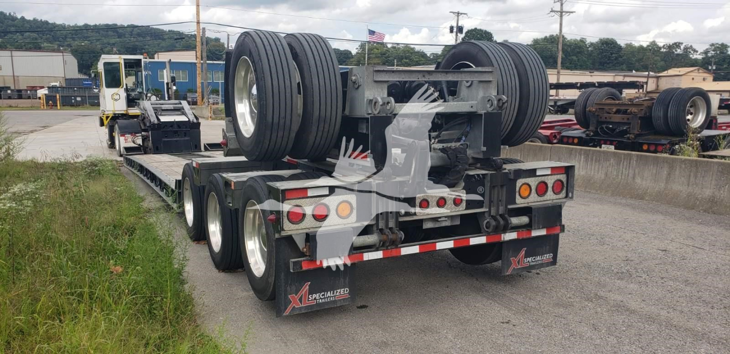 Trailer rear view of a used XL Specialized XL110Hdgs15 lowboy trailer showing dual rear axles, large tires, and reflective safety lights.