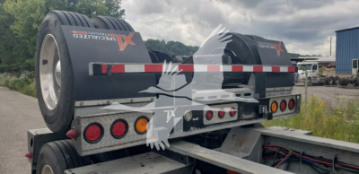 XL Specialized XL110Hdgs15 trailer showing rear with dual tires, red/white reflective strip, and multiple lights. Visible branding reads 'XL Specialized' on the bunks.