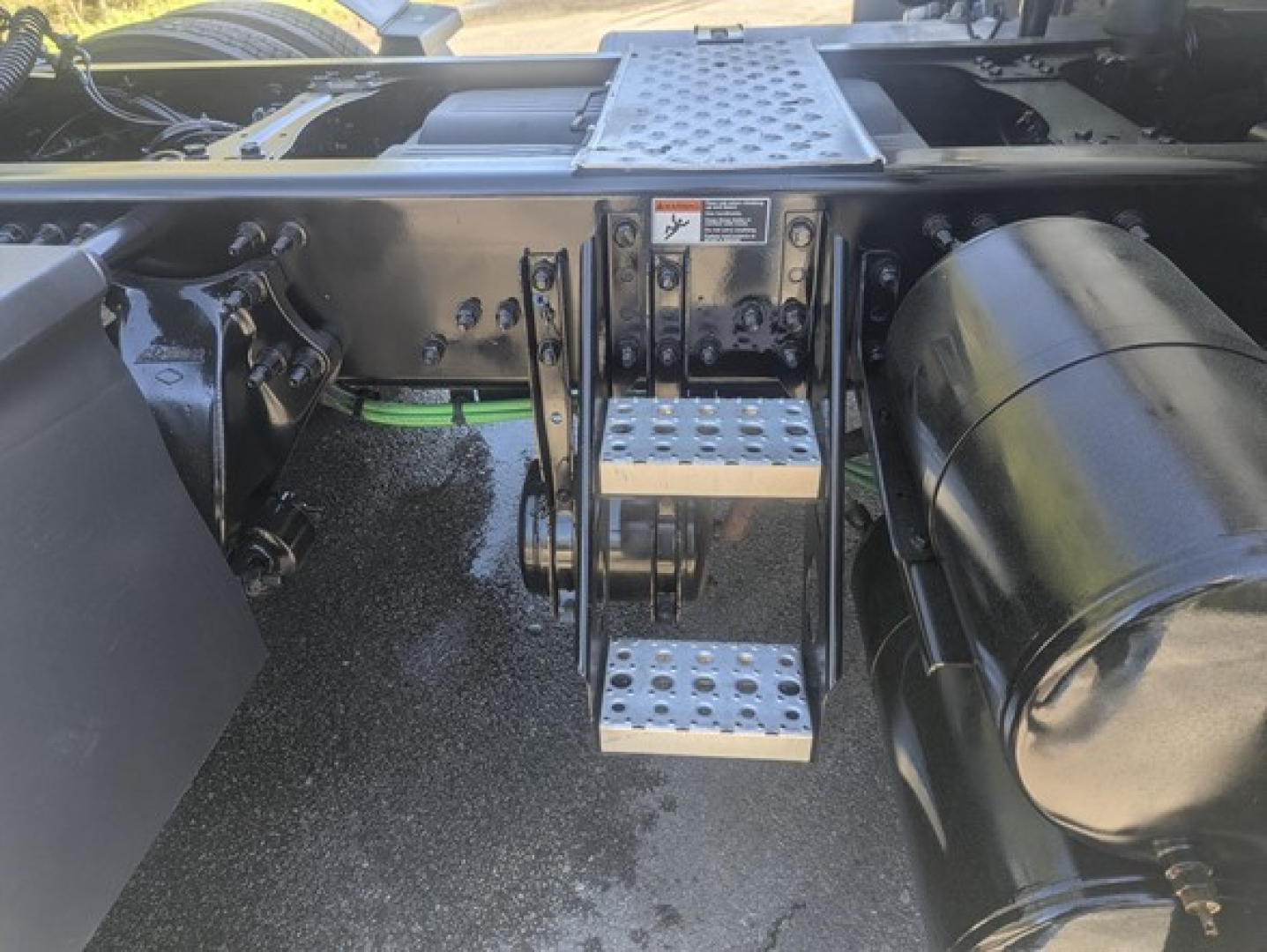 Truck step area of a 2021 Freightliner Cascadia 126 showing metal perforated steps and side components.