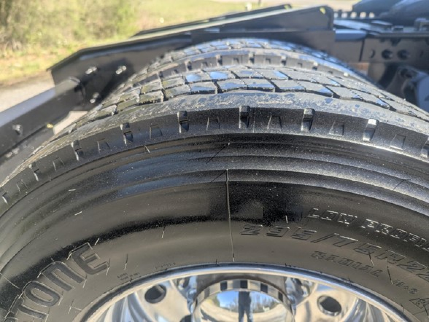Tire and wheel visible on Freightliner Cascadia truck, with tread and sidewall markings. The image shows a close-up of the tire with brand and size text partially visible.