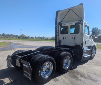 Truck rear view of a 2021 Freightliner Cascadia 126 day cab showing dual rear axles and the raised sleeper cab.