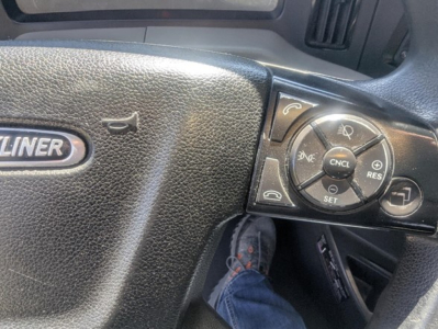 Volvo-style steering wheel controls on Freightliner Cascadia dash showing cruise control buttons and instrument panel.
