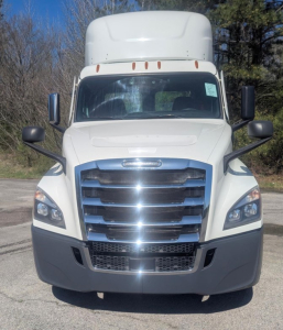 Front view of a white 2021 Freightliner Cascadia 126 day cab truck showing prominent chrome grille, large bumper, and side mirrors.