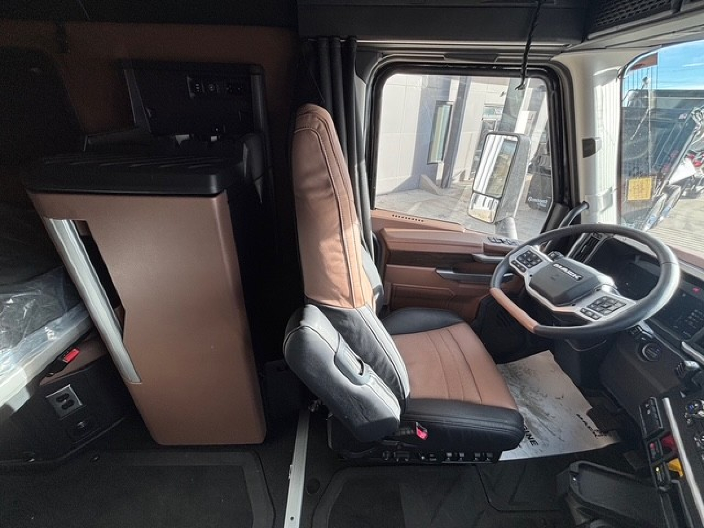 Cab interior of a 2026 Mack PR64T76H truck showing driver's seat, steering wheel, and dashboard components.