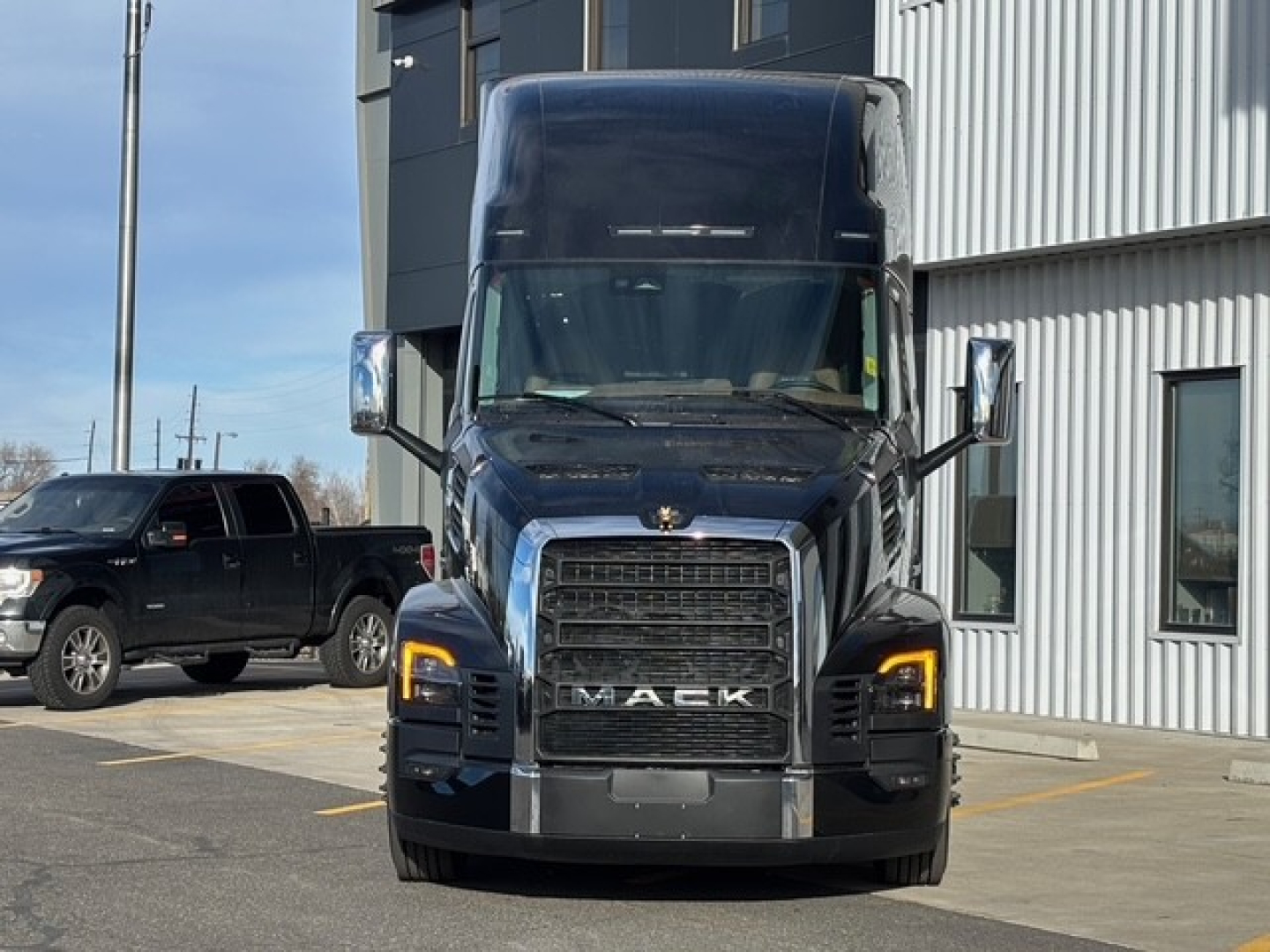 Mack PR64T76H heavy-duty truck front view showing grille, headlights, and large chrome bumper.