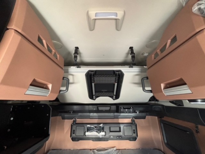 Mack PR64T76H cabin interior showing overhead bunk area and storage panels with control console and cup holders.