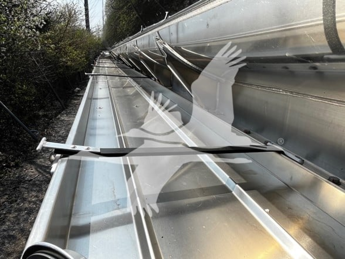 Trailer side with metal rails and a wiper showing a Heil 4-Comp trailer label and stainless surfaces.