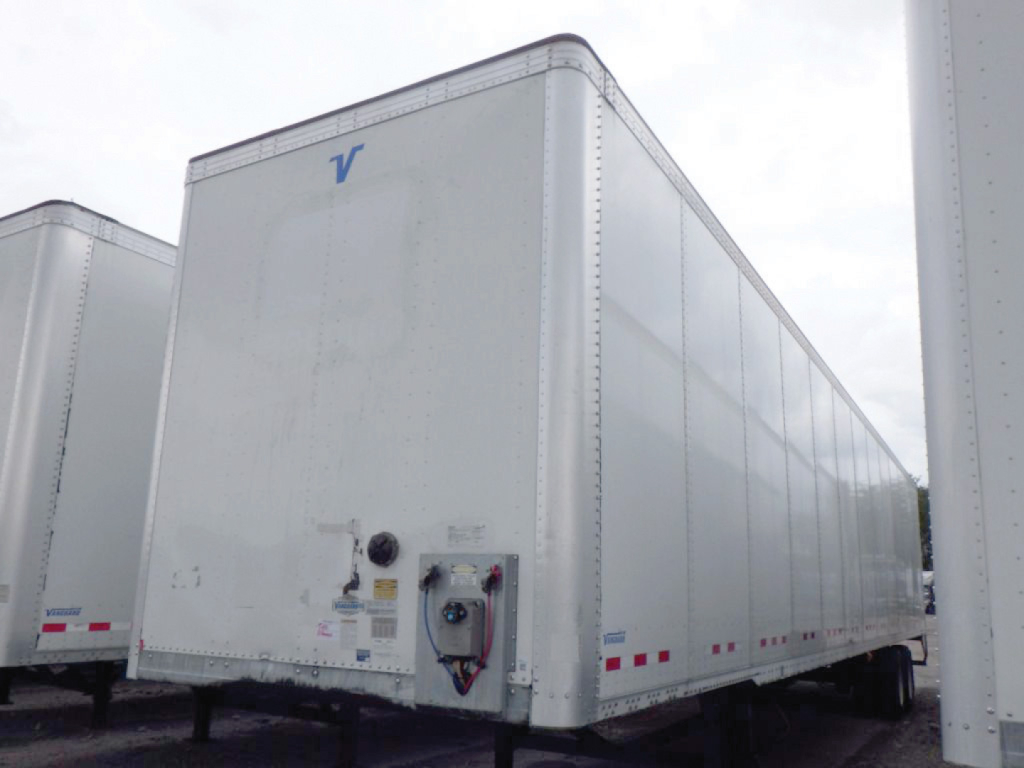 Trailer exterior showing the front of a white Vanguard dry van trailer with a small blue Vanguard logo near the top and a rear entry door mechanism.