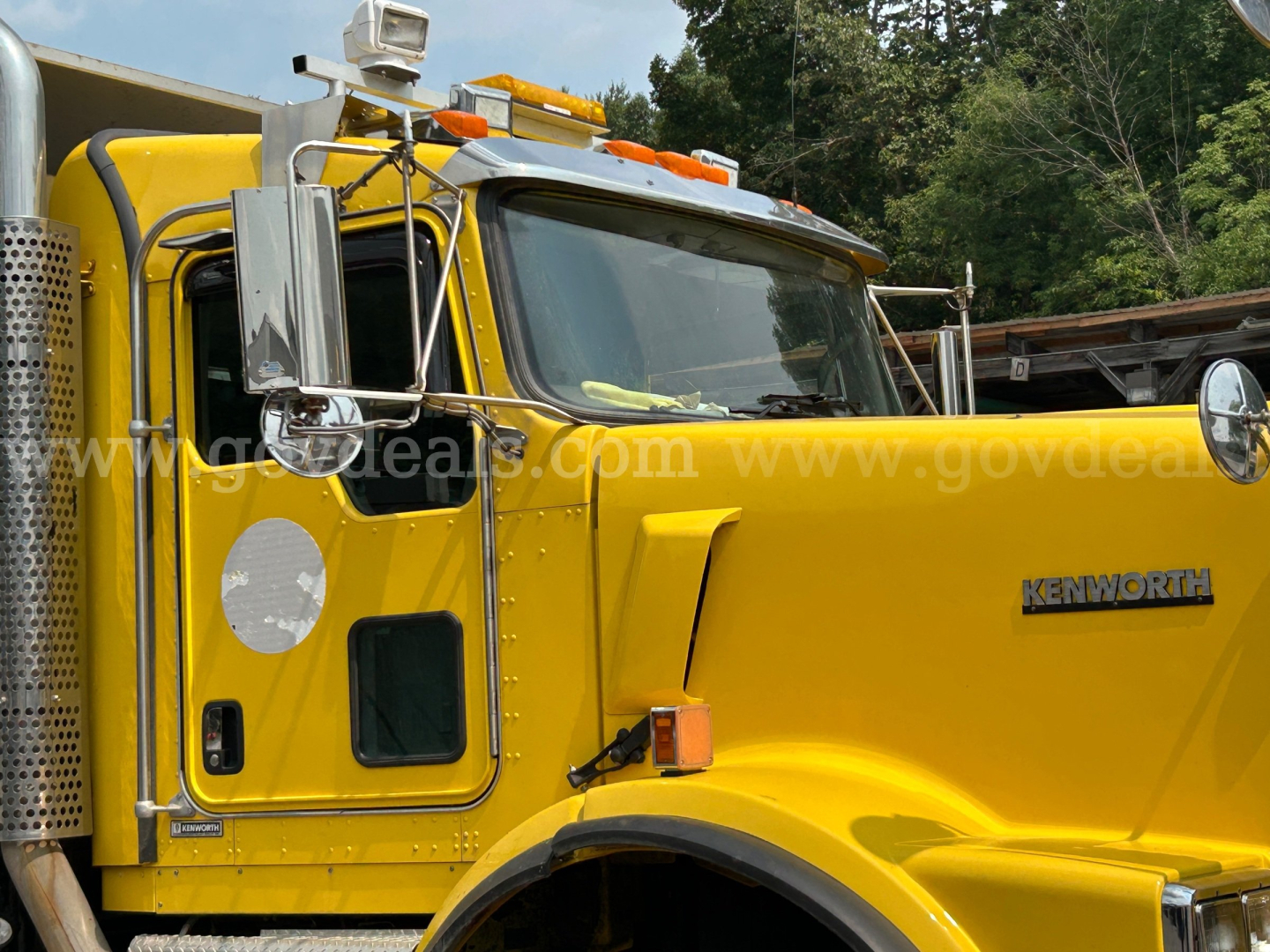 Kenworth T800 truck in yellow plow prime with front grille and side mirror, cab area with Kenworth emblem