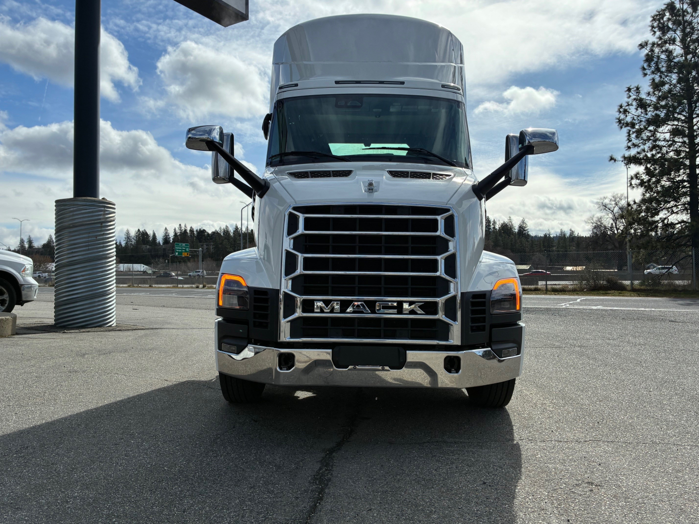Front view of a white 2027 Mack AN64T conventional daycab truck with chrome grille and large bumper.