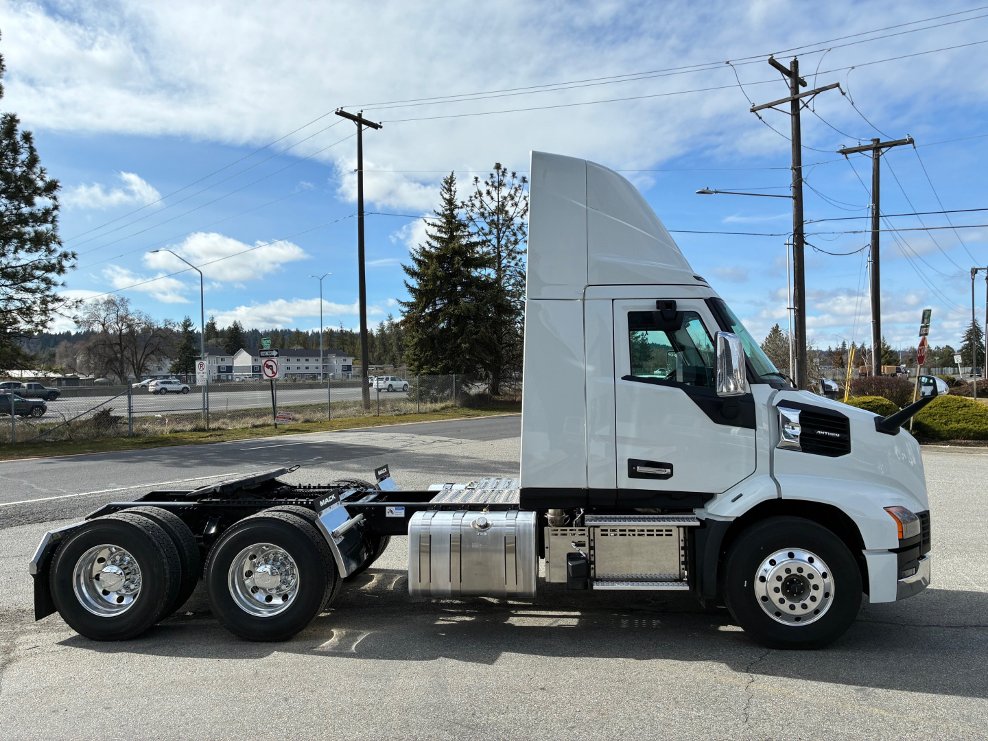 Conventional daycab truck side view with tall vertical cab, chrome fuel tanks, and dual rear axles; Mack AN64T designation not visible.