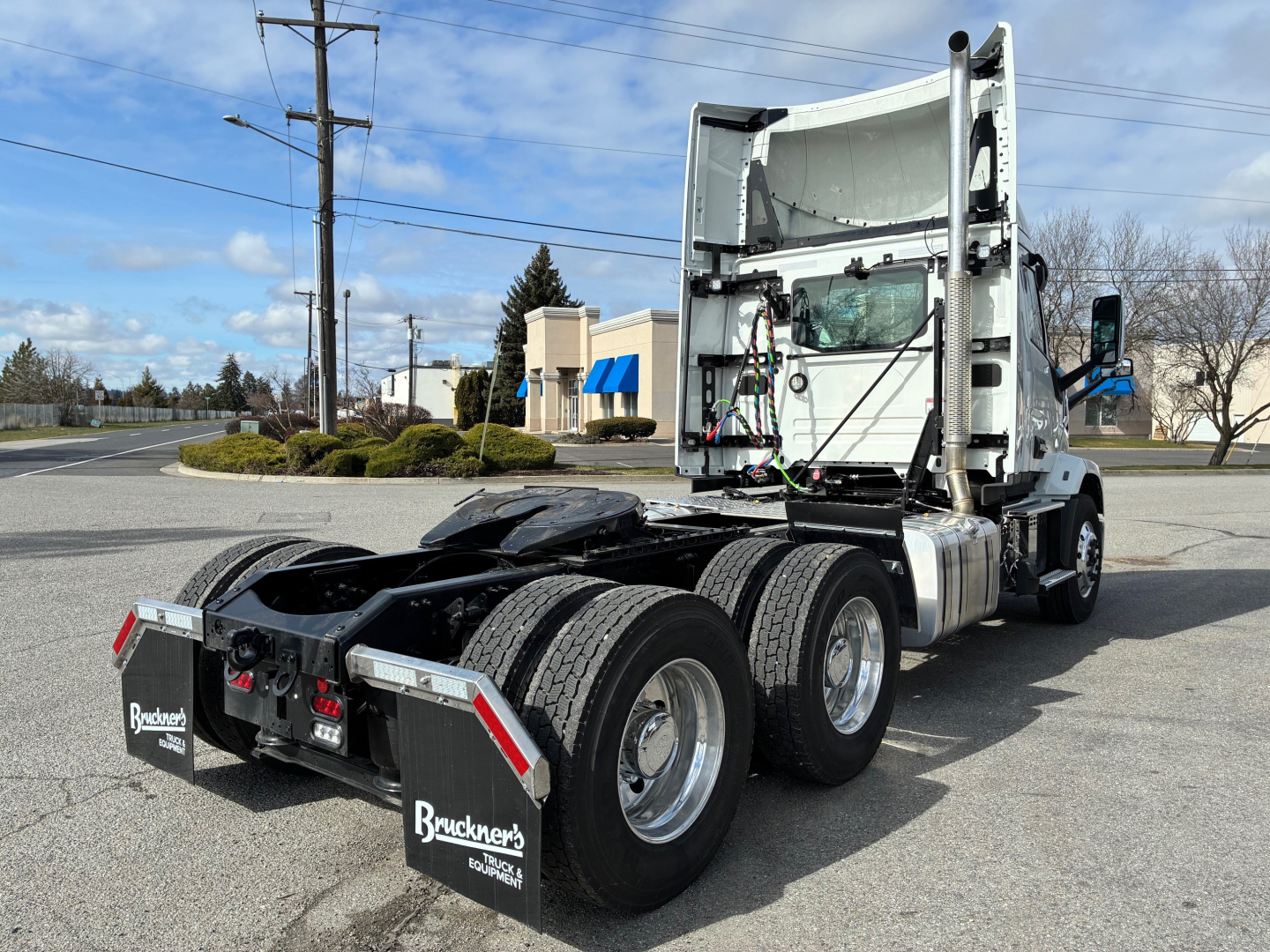 Mack AN64T semi truck tractor rear/side view showing fifth-wheel undercarriage and dual rear axles, white cab, black chassis.