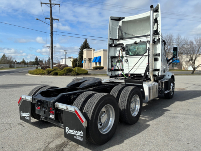 Mack AN64T semi truck tractor rear/side view showing fifth-wheel undercarriage and dual rear axles, white cab, black chassis.