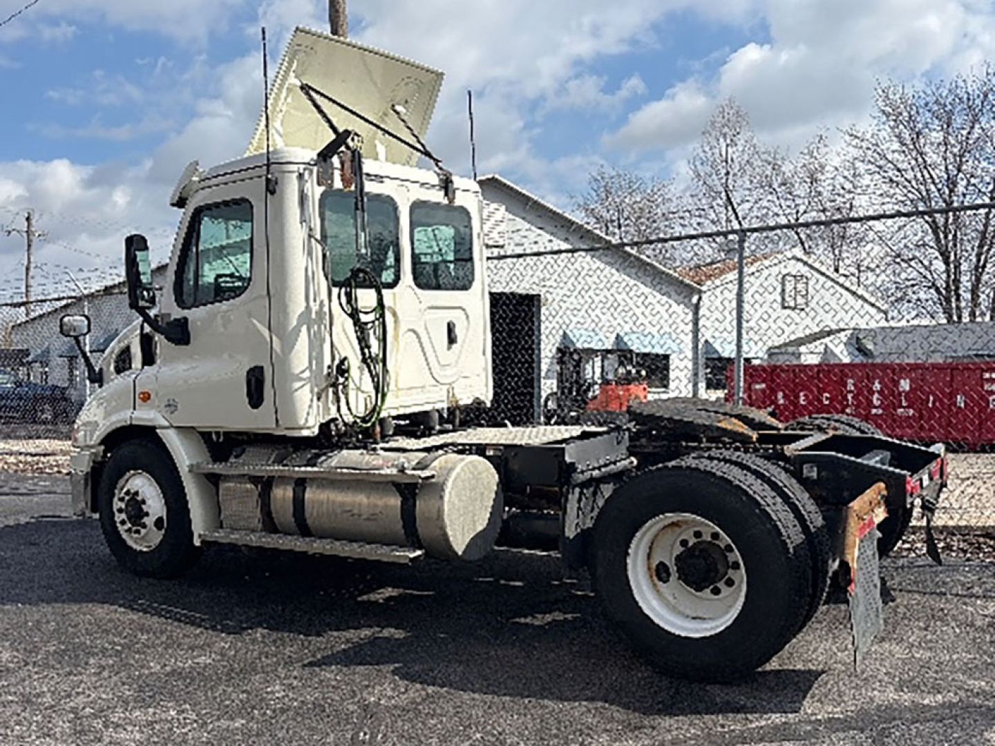 Truck chassis and cab of a 2020 Freightliner Cascadia 113 daycab with raised dump-style hood, visible fuel tanks, and rear drive axle; stock number 557218.
