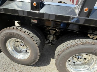 Western Star 47X dump truck rear dual wheels with Michelin tires and chrome rims, undercarriage and suspension visible.