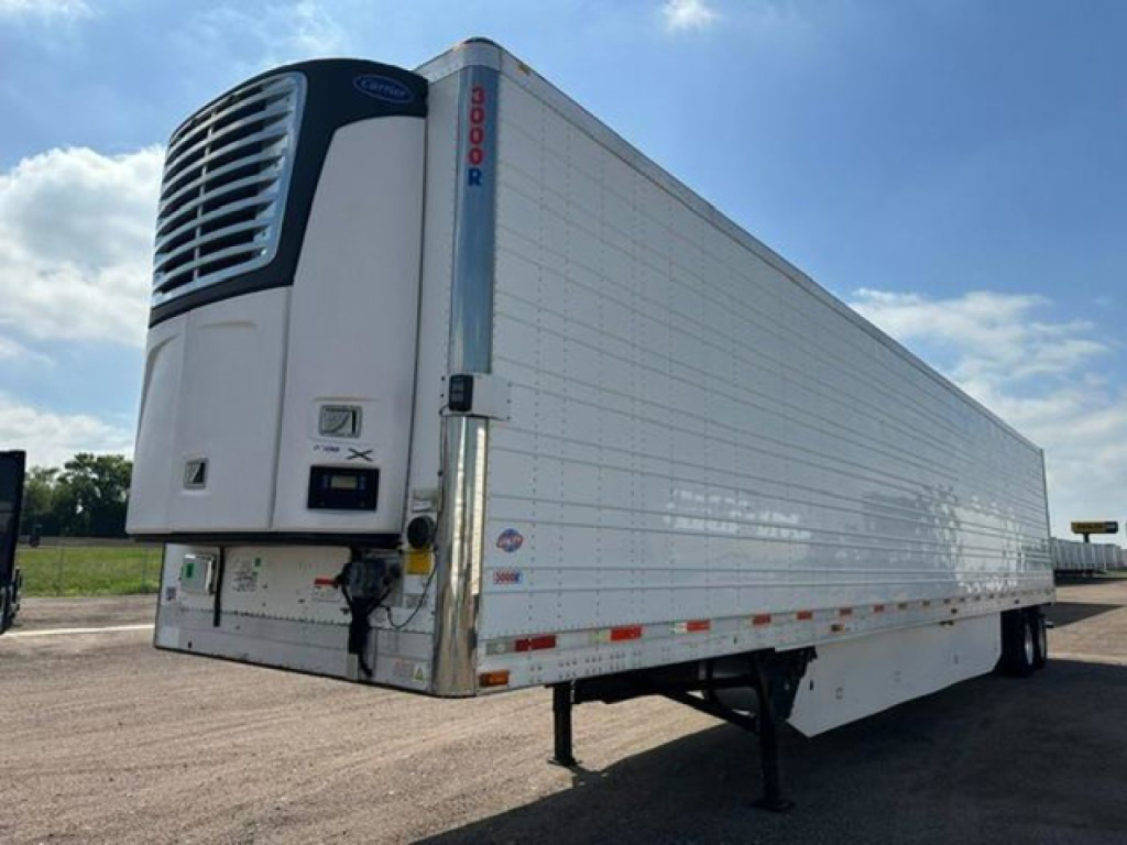 Trailer refrigeration unit on a 2016 Utility reefer trailer showing a blue and white Thermo King or similar refrigerator unit at the front with a vertical door/side rails, trailer body with white insulated panels, undercarriage and landing 