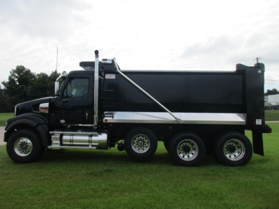Western Star 49X dump truck side profile showing black cab, large dump bed, chrome accents, dual rear axles, and a chrome exhaust stack.