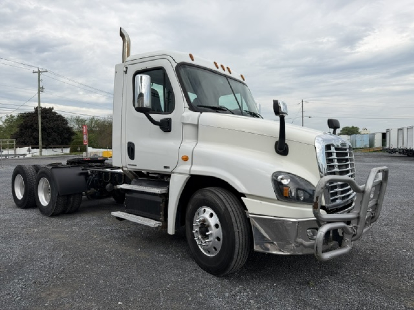 2017 Freightliner Cascadia CA125DC truck cab with chrome bumper and dual rear axles visible.