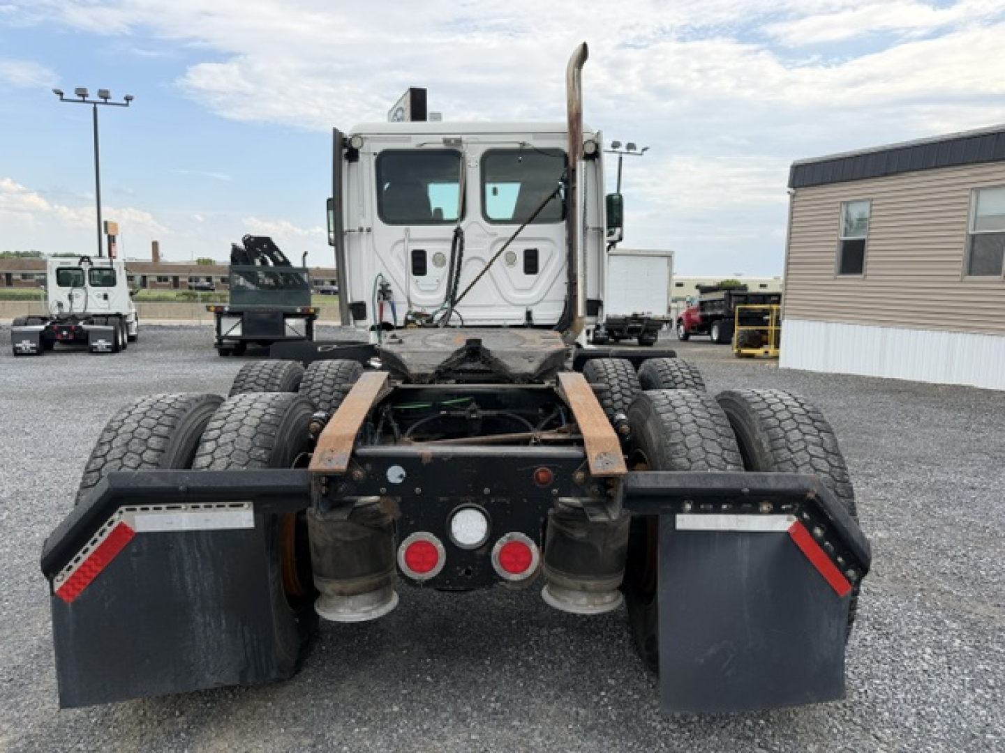 Truck rear view of a 2017 Freightliner Cascadia CA125DC showing dual rear axles, fifth wheel/kingpin area, taillights, mudflaps, and bumper panels.