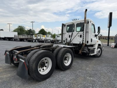 Truck cab and chassis of a 2017 Freightliner Cascadia CA125DC conventional daycab rear view showing tandem axle and fifth wheel area.