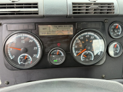 Truck dash panel showing gauges and digital display in a 2017 Freightliner Cascadia cab; visible text includes MPG, trip data, and various gauge readings.