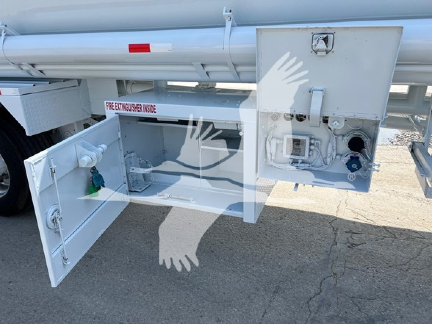 Petroleum tank trailer rear access panel open showing pump and control box, with secondary cabinet containing valves and safety labels.