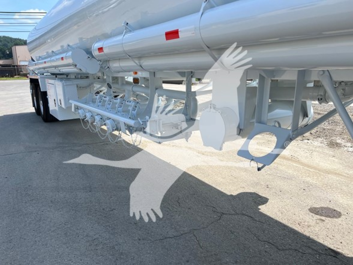 Fuel trailer underside showing tanker, hoses, and support frame with multiple compartments and brackets.