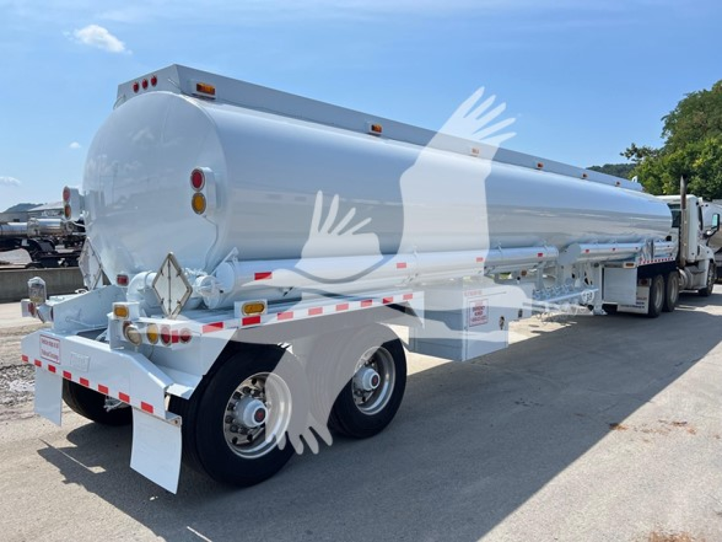 Tank trailer showing cylindrical Heil petroleum fuel tank with rear view, twin-axle wheels, safety reflectors, and rear lights.