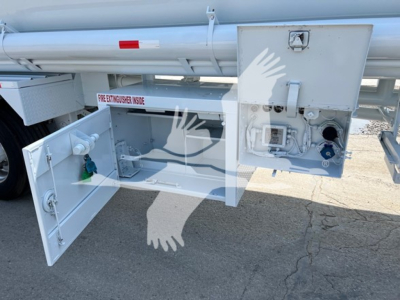 Petroleum tank trailer rear access panel open showing pump and control box, with secondary cabinet containing valves and safety labels.