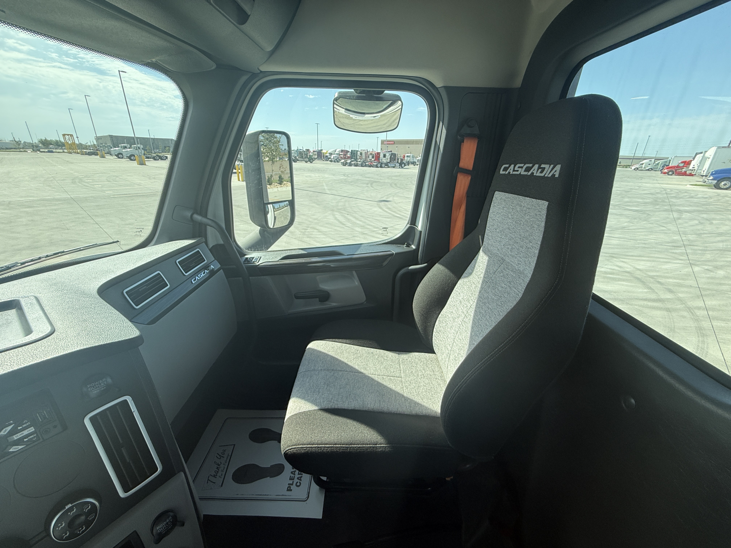 Truck cab interior showing driver seat with Casciaia branding, dashboard controls, and windshield view; no other labels visible.