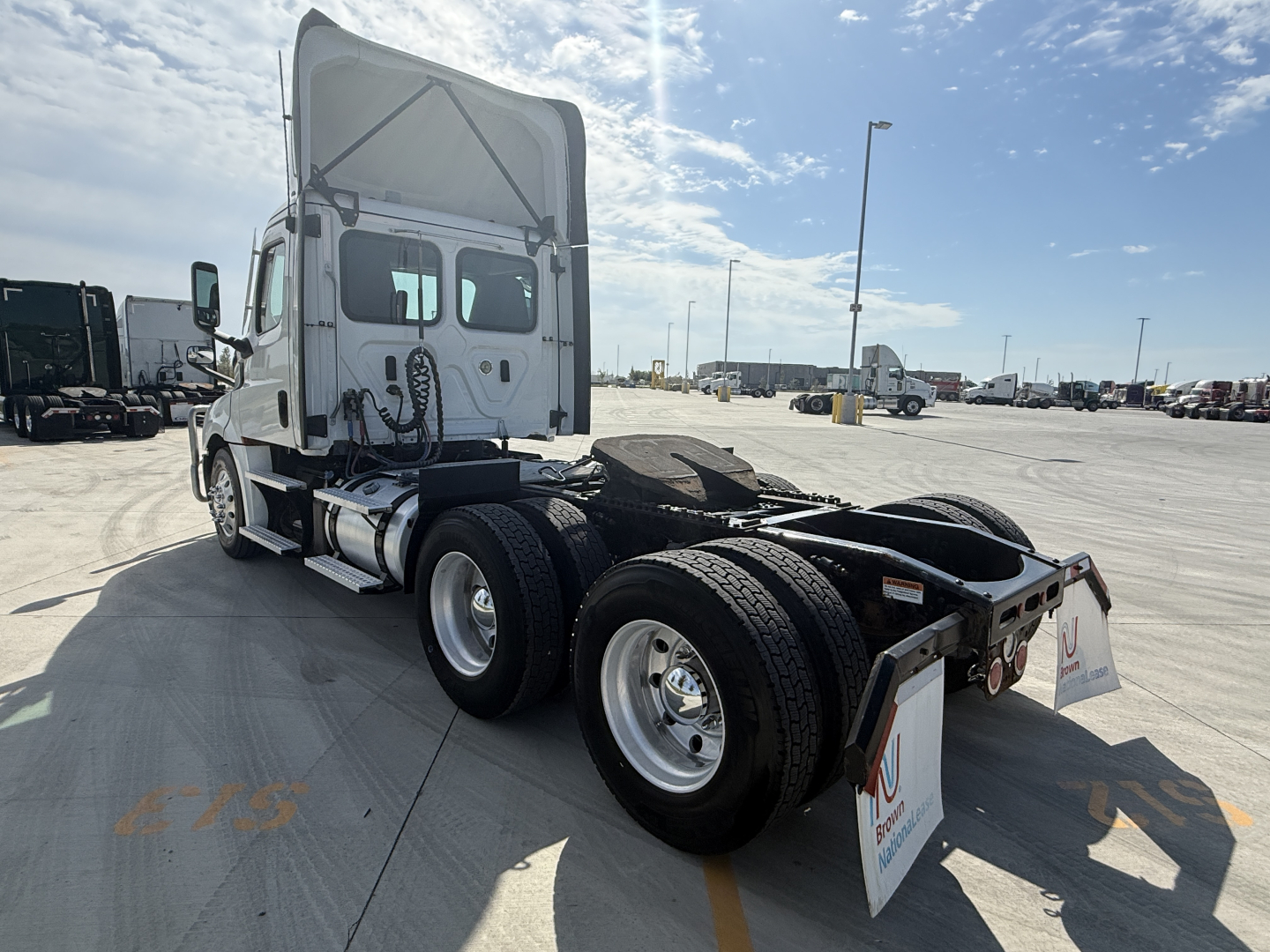 Truck chassis and cab of a white Freightliner PT126064S T with dual rear axles, side view, showing rear wheels and fifth wheel area.
