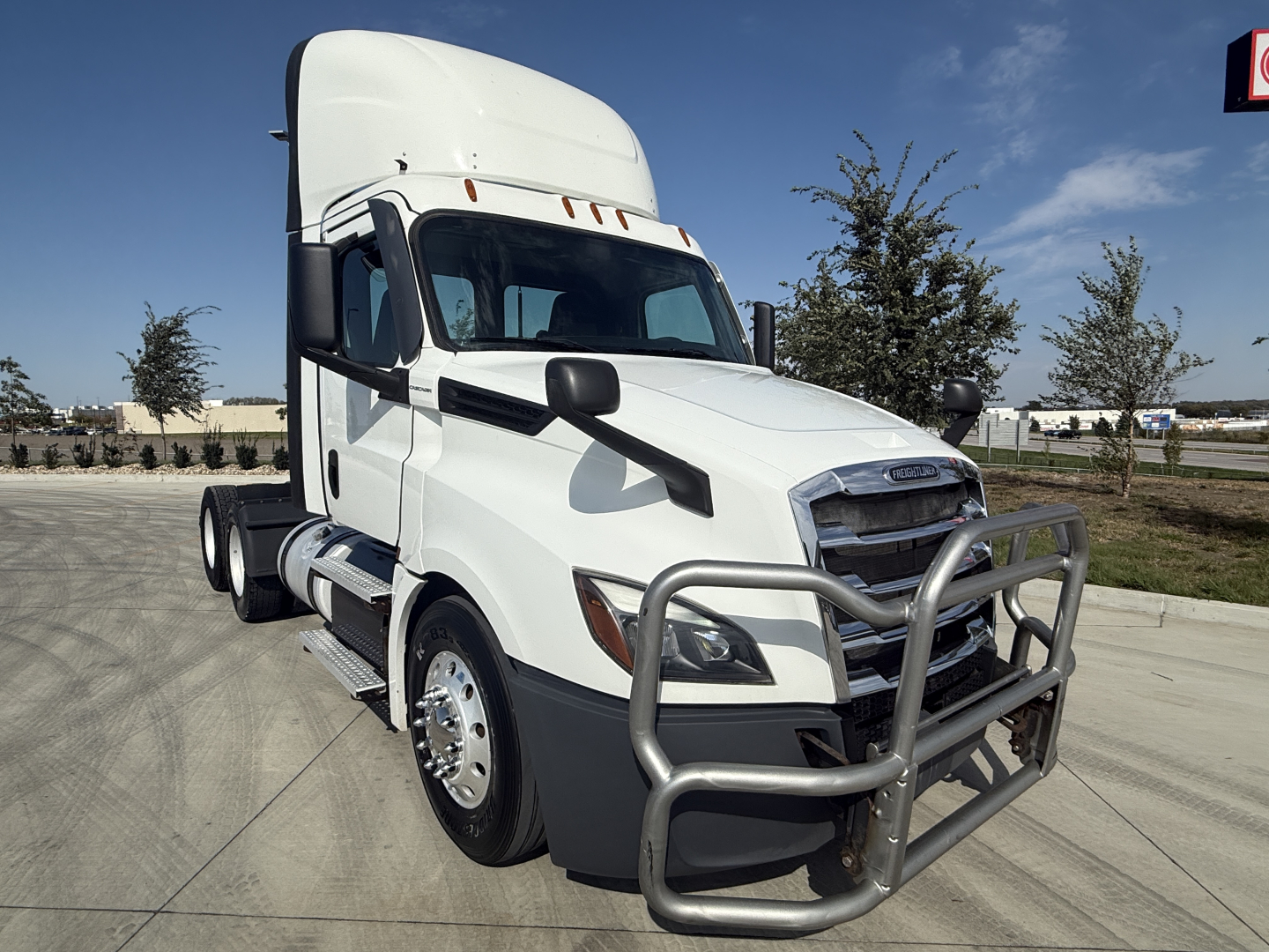 Truck cab with white Freightliner daycab showing front bull bar guard and large grille. No visible text on components.